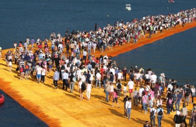 epa05375852 People walk the 'The Floating Piers' by  Bulgarian artists Christo and Jeanne-Claude on Lake Iseo during the opening of the art work near Sulzano, northern Italy, 18 June 2016. The 'Floating Piers' with their bright orange covers will be open until 03 July and will connect the two towns Sulzano and Monte Isola.  EPA/FILIPPO VENEZIA