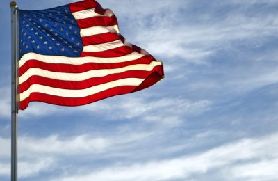 A vivid American Flag flys on a blue sky