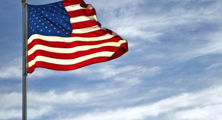 A vivid American Flag flys on a blue sky