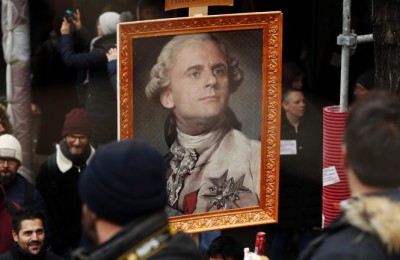 epa08046776 Protesters hold a portrait of French President Emmanuel Macron portrayed as Louis XVI King of France during a demonstration against pension reforms Paris, France, 05 December 2019. Unions representing railway and transport workers and many others in the public sector have called for a general strike and demonstration to protest against French government's reform of the pension system.  EPA/CHRISTOPHE PETIT TESSON