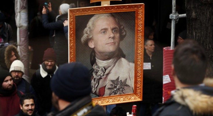 epa08046776 Protesters hold a portrait of French President Emmanuel Macron portrayed as Louis XVI King of France during a demonstration against pension reforms Paris, France, 05 December 2019. Unions representing railway and transport workers and many others in the public sector have called for a general strike and demonstration to protest against French government's reform of the pension system.  EPA/CHRISTOPHE PETIT TESSON