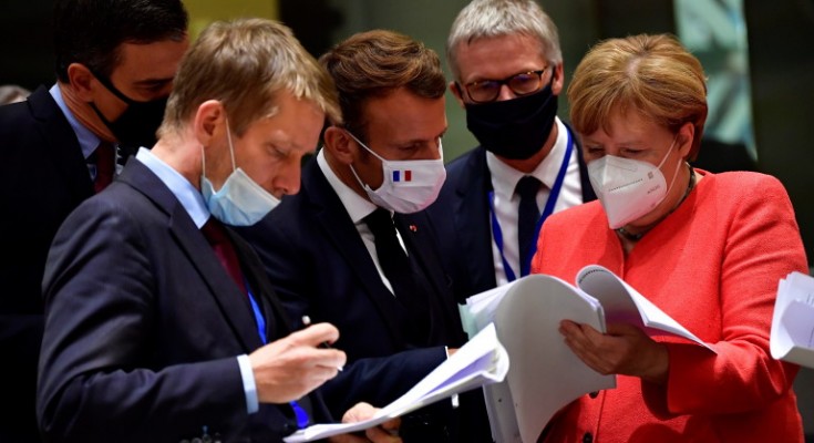 epaselect epa08557305 German Chancellor Angela Merkel (R) chats with French President Emmanuel Macron (C) while both wear face masks during a roundtable discussion on the fourth day of the ongoing Special European Council leaders' summit, the first face-to-face meeting between EU statespeople held since the eruption of the ongoing pandemic of the COVID-19 disease caused by the SARS-CoV-2 coronavirus, in Brussels, Belgium, 20 July 2020. The heads of state and government discussed the bloc's response to the pandemic and the new long-term budget.  EPA/JOHN THYS / POOL
