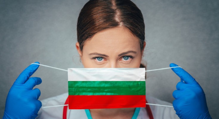 Coronavirus in Bulgaria Female Doctor Portrait hold protect Face surgical medical mask with Bulgaria National Flag. Illness, Virus Covid-19 in Bulgaria, concept photo