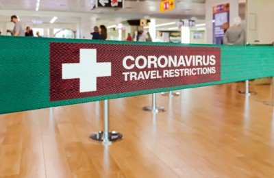 Green ribbon barrier inside an airport with the warning of travel restrictions due to the spread of the dangerous Coronavirus