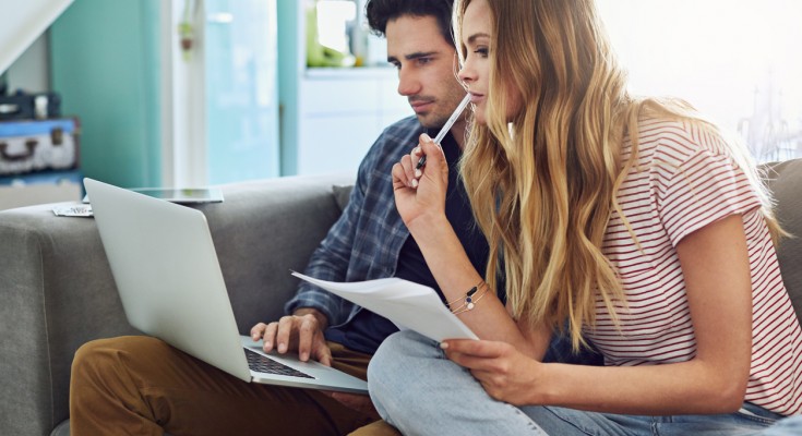 Cropped shot of a young attractive couple planning their home budget together on the sofa in the living room at home