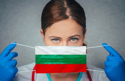 Coronavirus in Bulgaria Female Doctor Portrait hold protect Face surgical medical mask with Bulgaria National Flag. Illness, Virus Covid-19 in Bulgaria, concept photo
