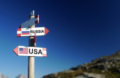 Russian and American flags in two directions on road sign. Relationships and differences in diplomacy, strategy and interests.