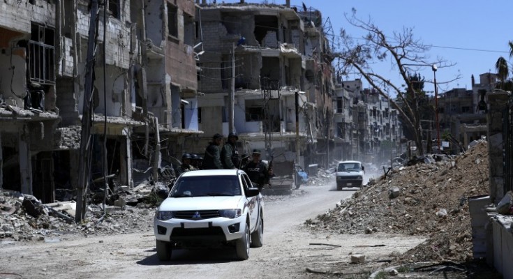 epa06673241 Cars drive through destruction in Douma city, Eastern Ghouta, the countryside of Damascus, Syria, 16 April 2018. According to media reports, the Syrian army had recently driven the rebel fighters of Jaysh al-Islam (Army of Islam) out of the city. Jaysh al-Islam had control over Douma for the past six years.  EPA/STR