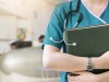 Cropped image of nurse in purple uniform holding green book on white background.Nurse, Student, Education